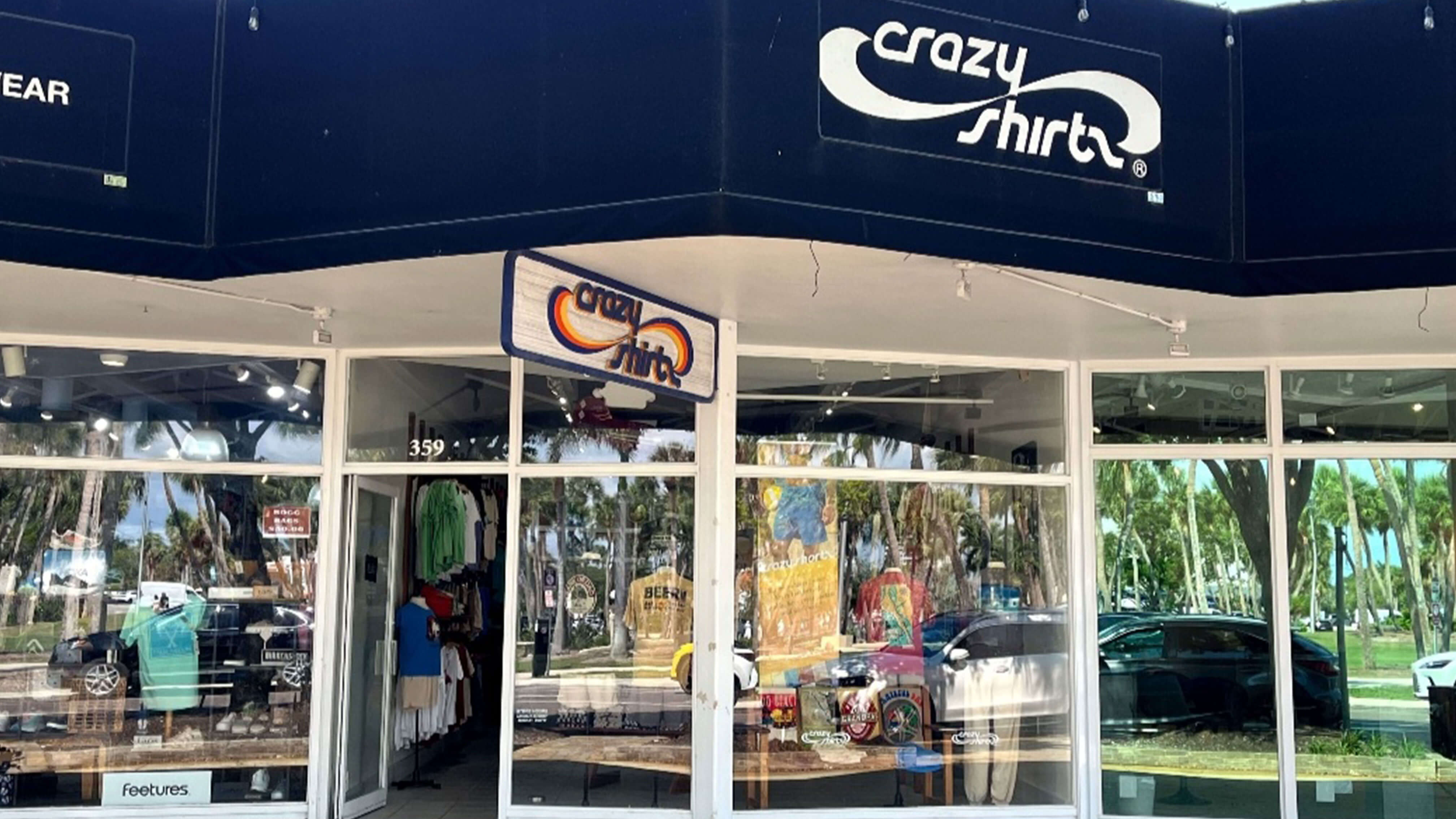 Sarasota storefront of 'Crazy Shirts' with large signage and glass windows.