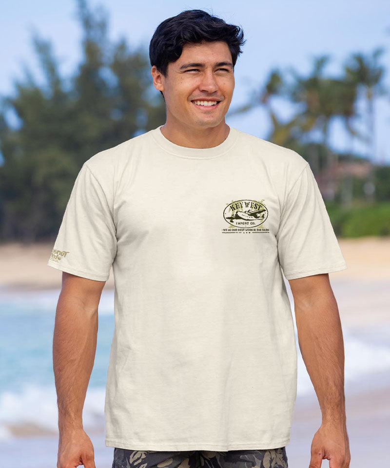 man wearing a beige tee with a logo on the front. View 3