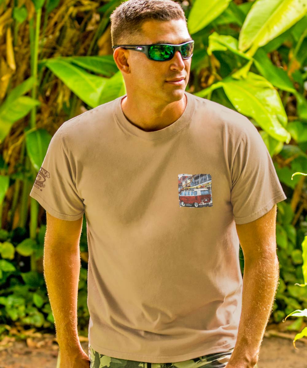 Man facing the camera wearing a beige crewneck t-shirt with a graphic of a Volkswagen van on the front chest. View 3
