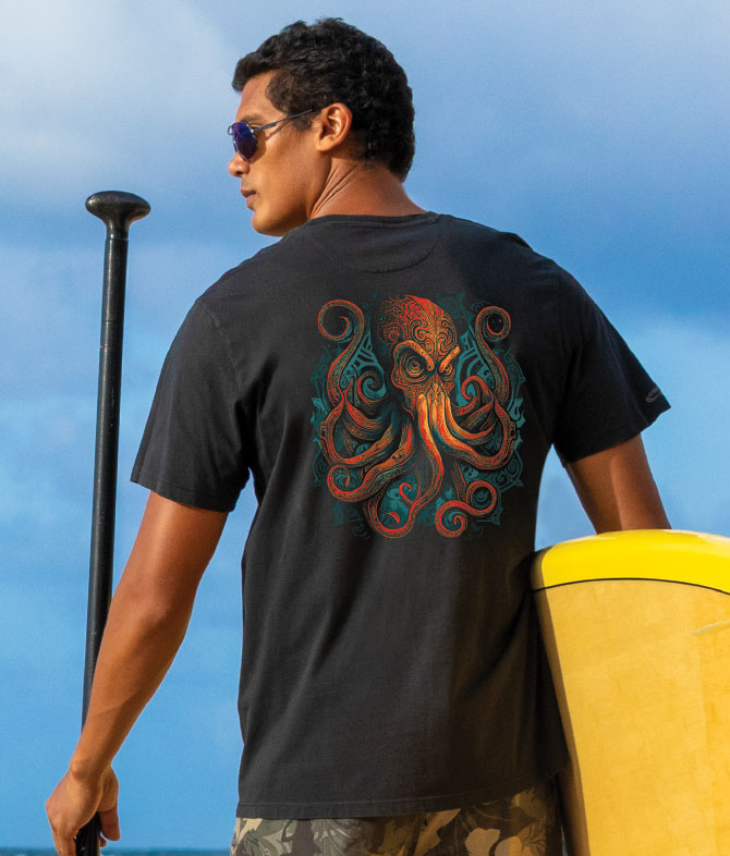 A man facing away from the camera wears a jet black short sleeve pima t-shirt with a tribal octopus design in orange and green on the back. View 2