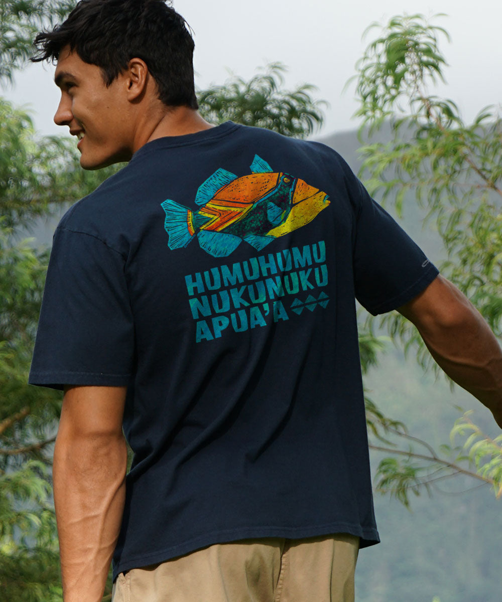 A person wearing a navy blue short sleeve crewneck T-shirt with a colorful fish design and text on the back. View 2