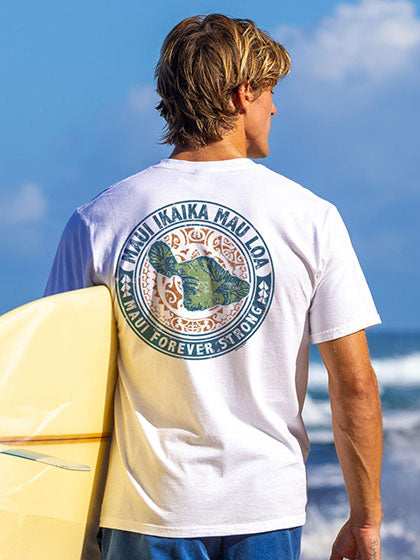 Man holding a surfboard with a t-shirt featuring a graphic design on the beach.