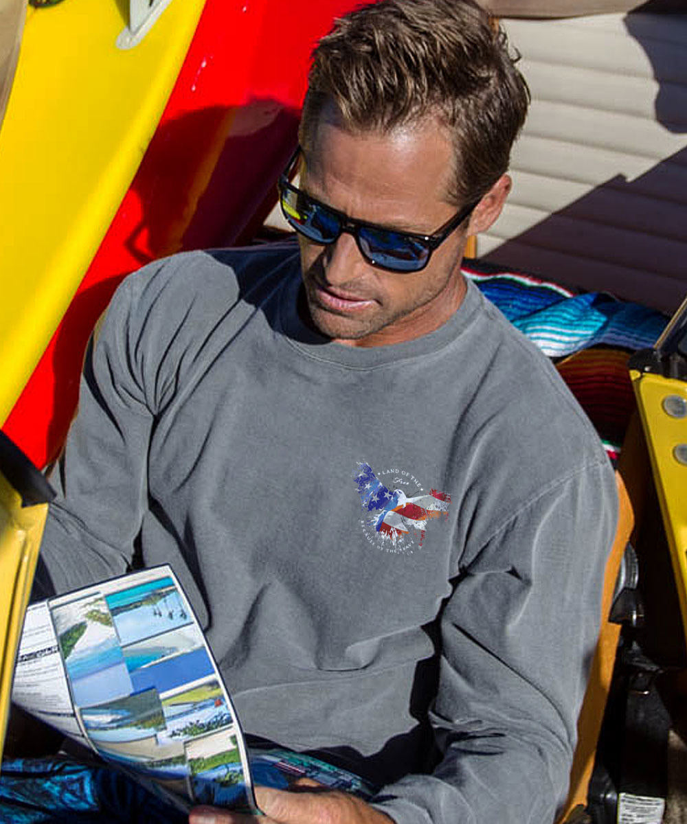 A person viewed from behind wearing a long sleeve crewneck t-shirt with a patriotic eagle design in red, white, and blue. View 3