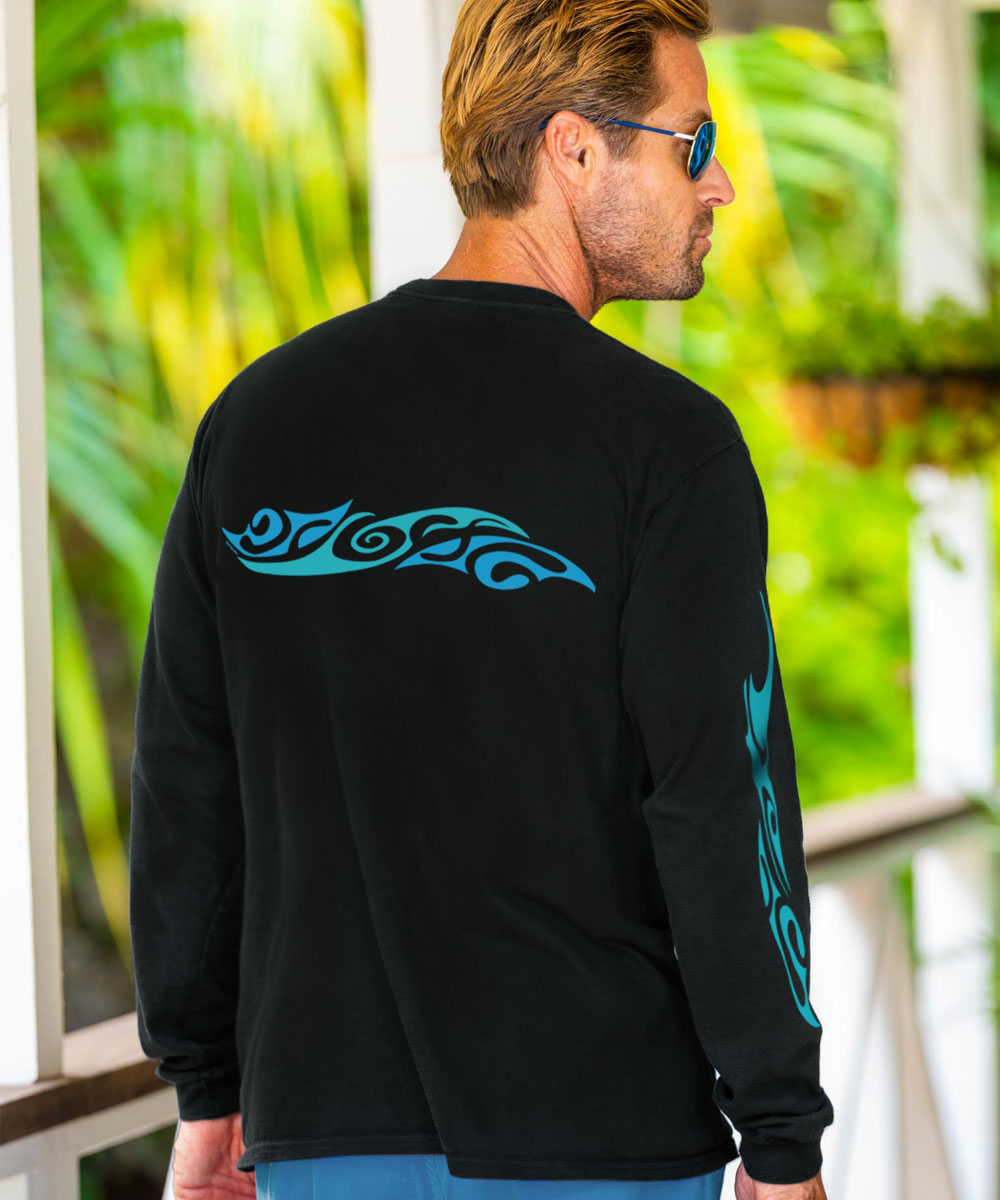 A man facing away from the camera wearing sunglasses and a black long sleeve crewneck T-shirt with a blue horizontal tribal wave design on the back, with greenery in the background. View 3