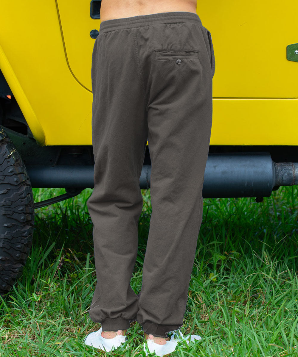 man wearing gray pants standing in front of a vehicle View 3
