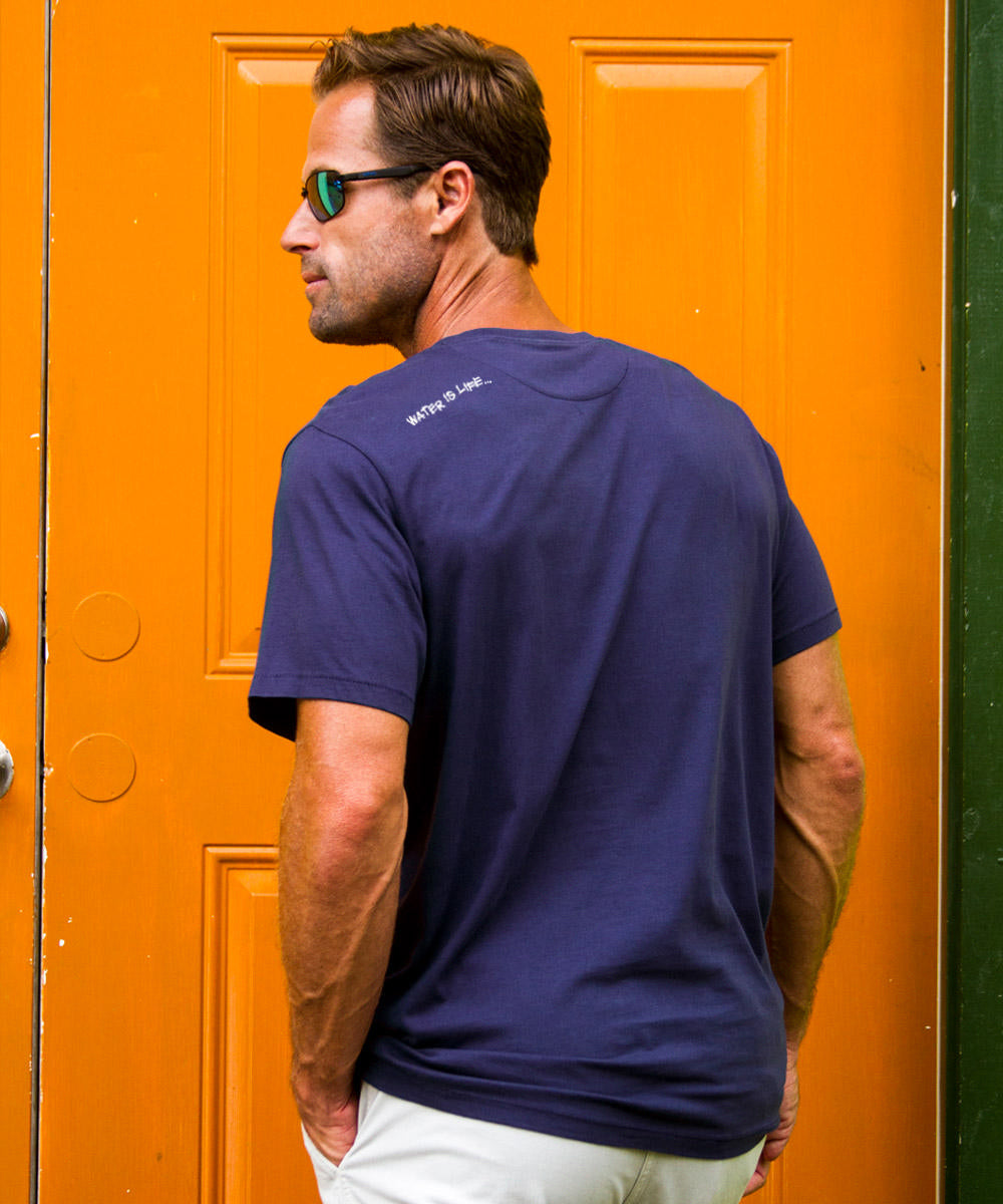 man wearing a blue shirt in front of an orange door View 3