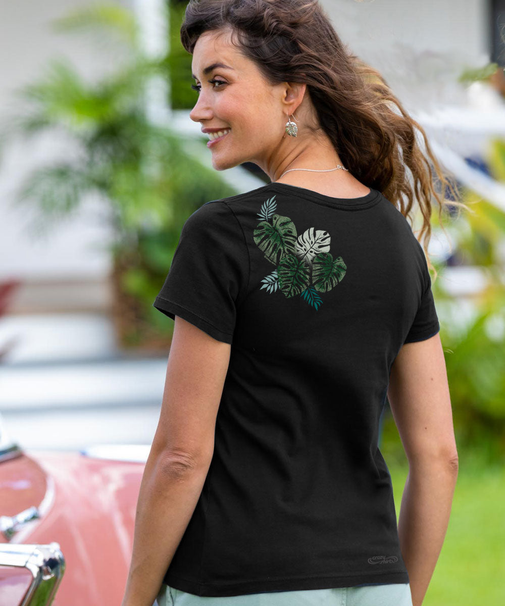 A woman wearing a jet black short sleeve pima t-shirt with a green tropical leaf design on the back upper left shoulder area. View 3