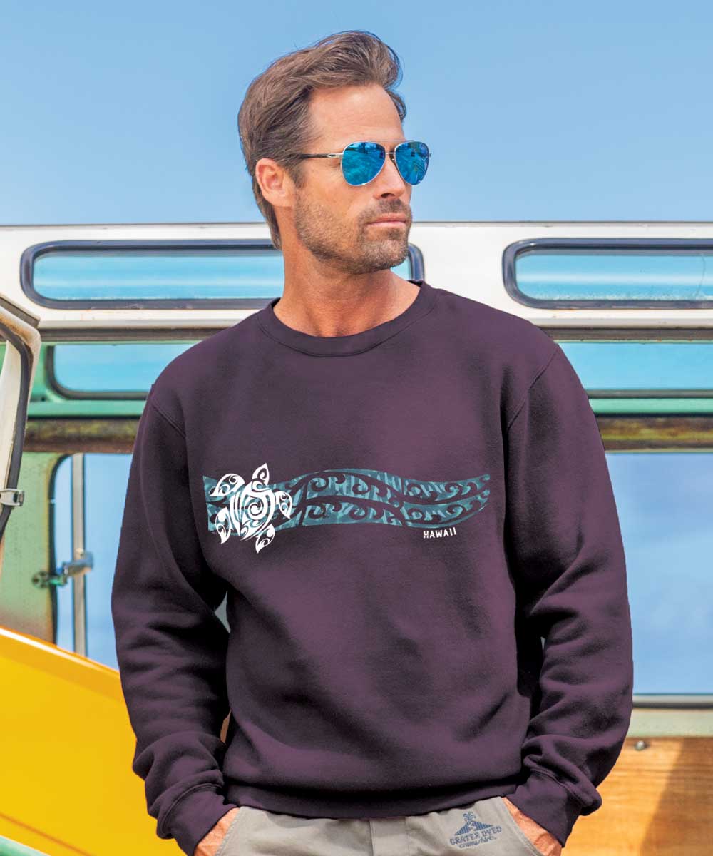 A man wearing sunglasses and a purple long sleeve sweatshirt with a turtle tattoo design in front of a vehicle. View 2
