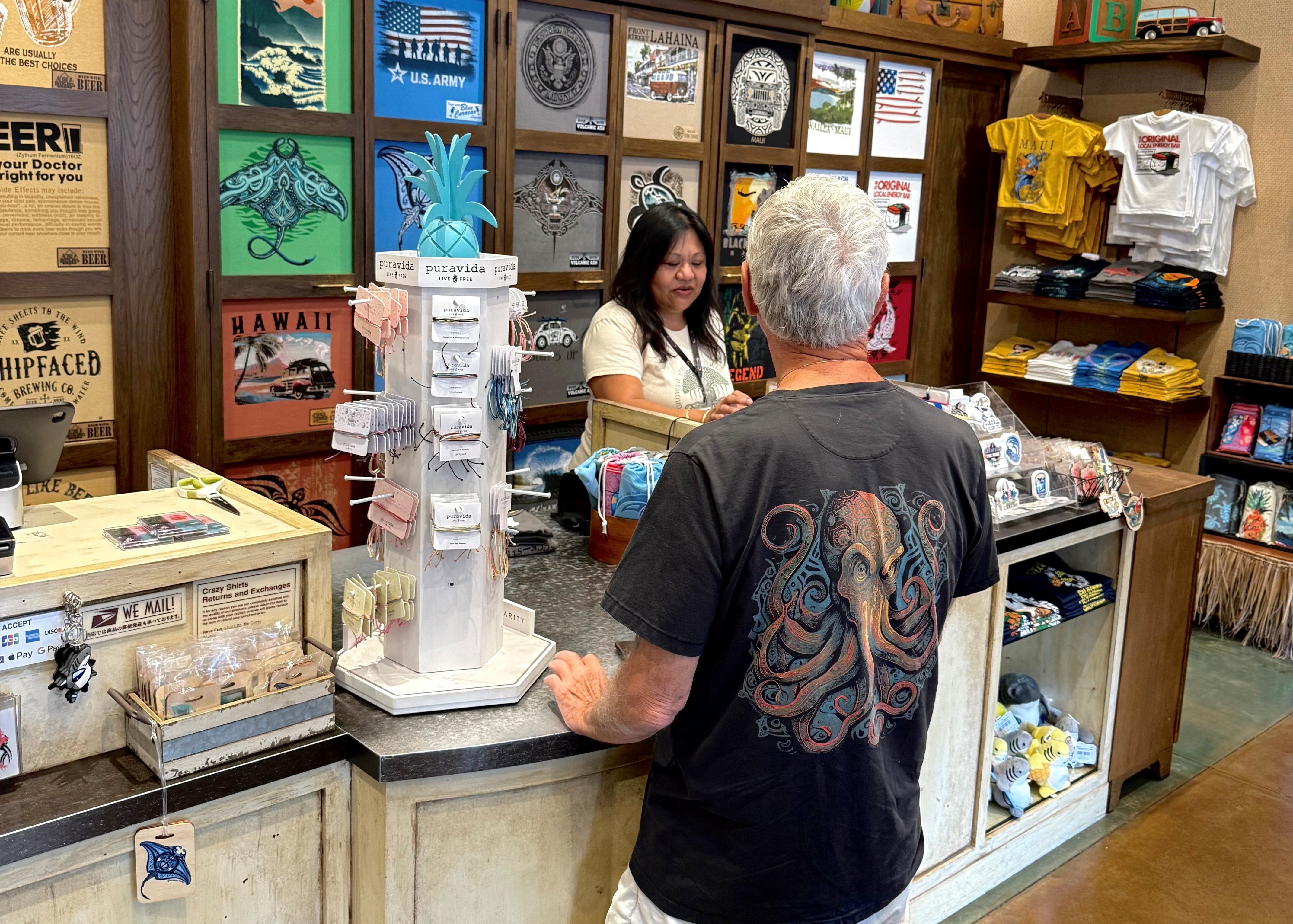 Customer inside of a Crazy Shirts store purchasing an item