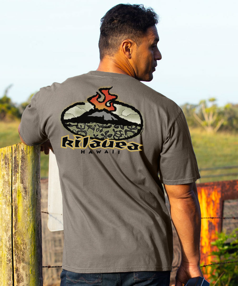 A man wearing a gray t-shirt with a large 'Kilauea Hawaii' volcano graphic on the back, photographed outdoors against a blurred natural background. View 2