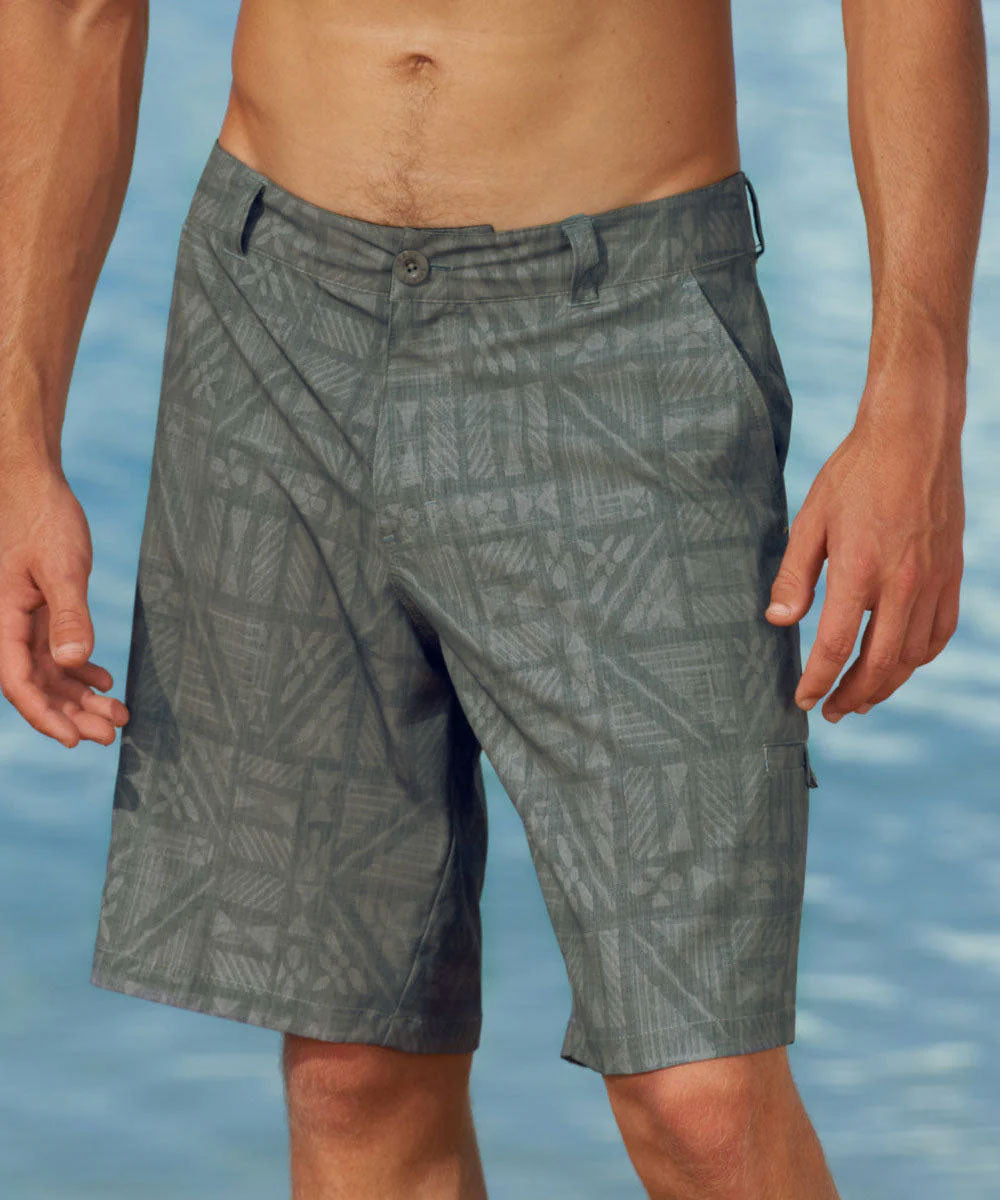 Grayish Green patterned shorts worn by a person with a blue water background View 2