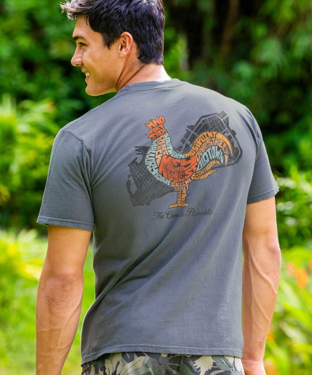 Man wearing a gray t-shirt with a colorful rooster design on the back, standing outdoors. View 2