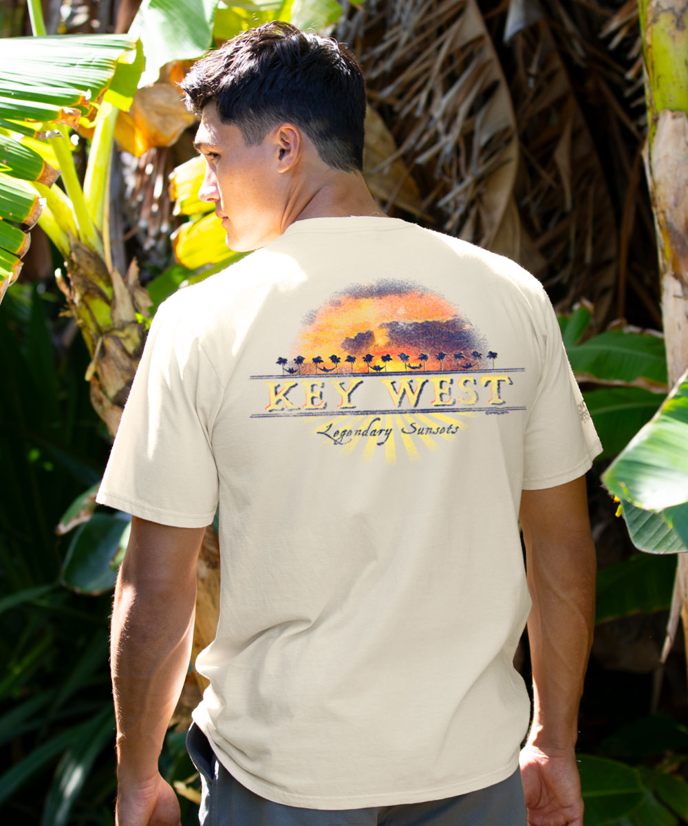 Man wearing a white t-shirt with 'Key West' graphic in a tropical setting View 2