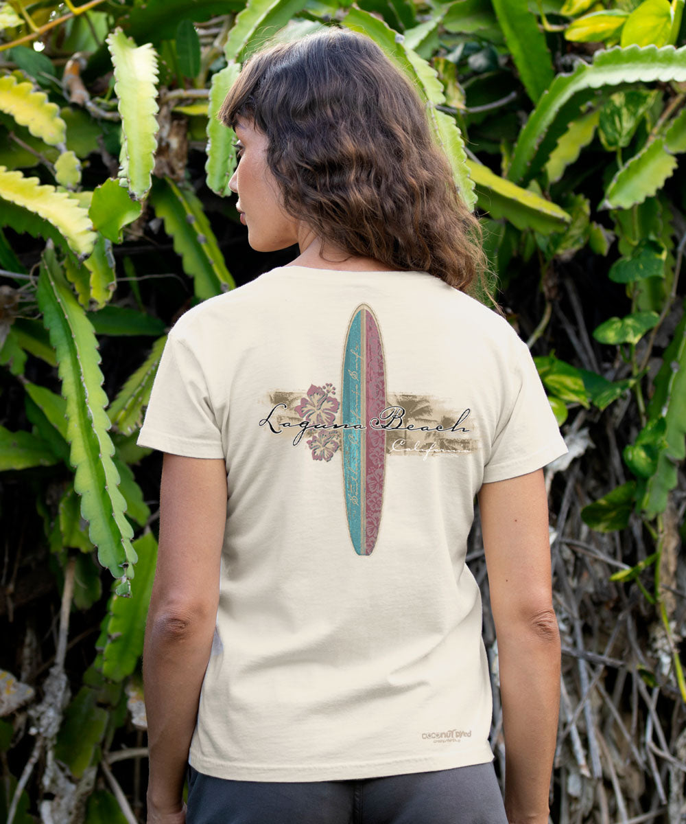 Person wearing a white t-shirt with a surfboard design and text in a natural setting View 3