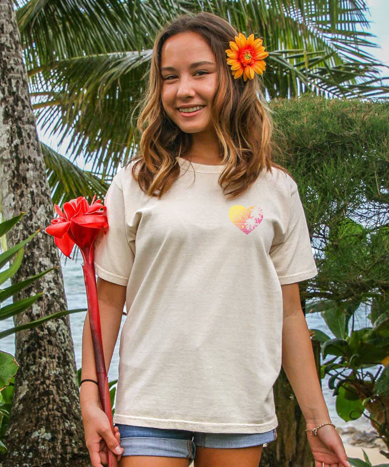 Young woman holding a red flower with palm trees in the background View 3