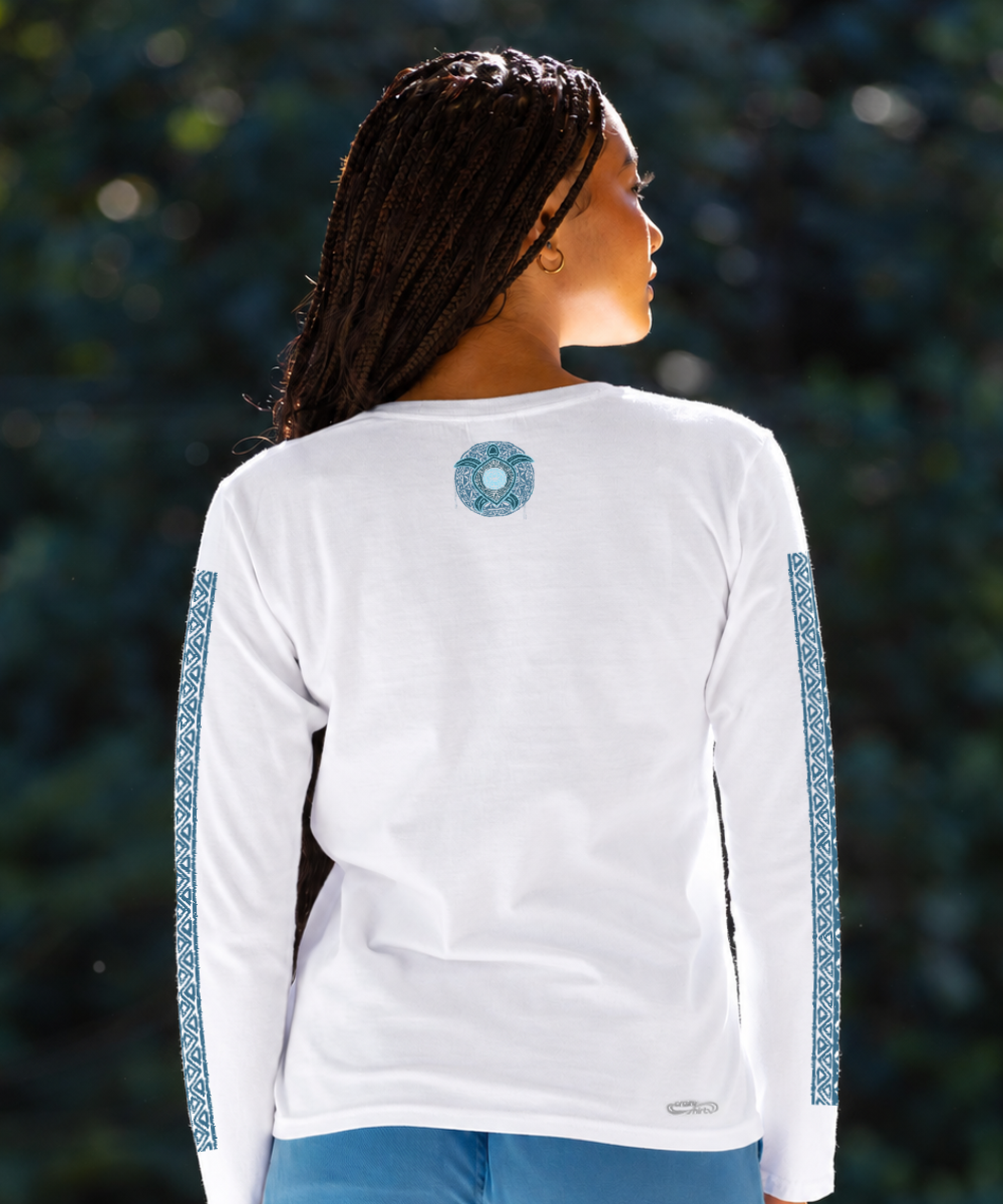 A woman shown from the back wearing a white long-sleeve shirt with blue patterned sleeve stripes and a blue circular graphic on the upper back, set against a blurred dark green outdoor background. View 3