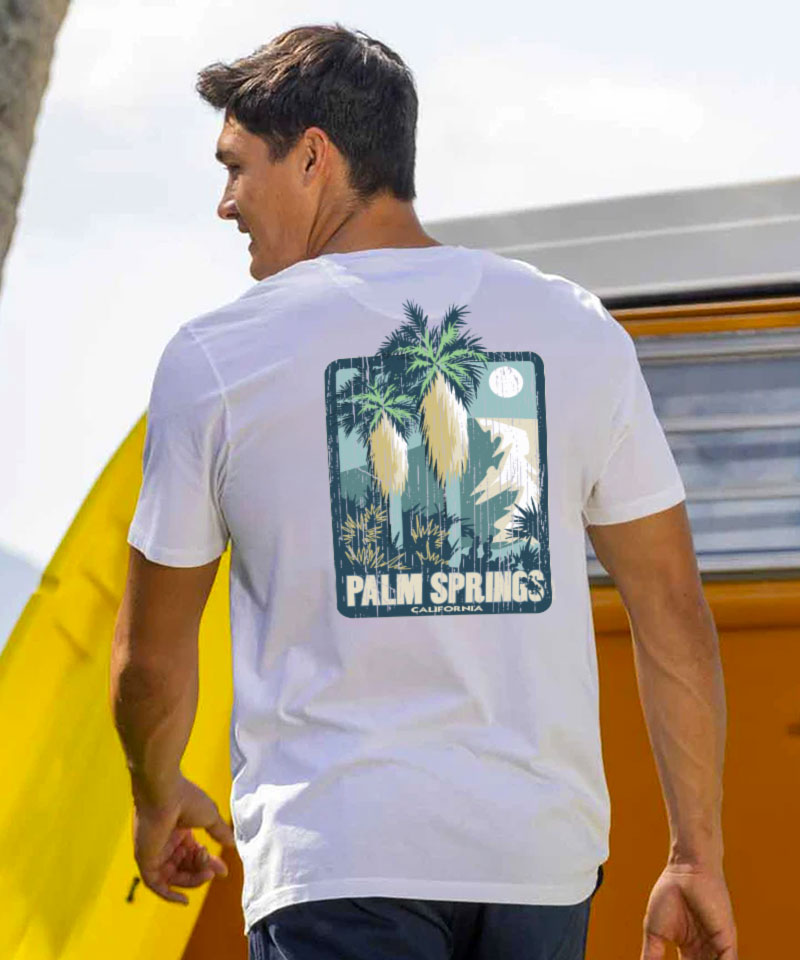 Man wearing a white t-shirt with a 'Palm Springs' graphic, standing outside View 2