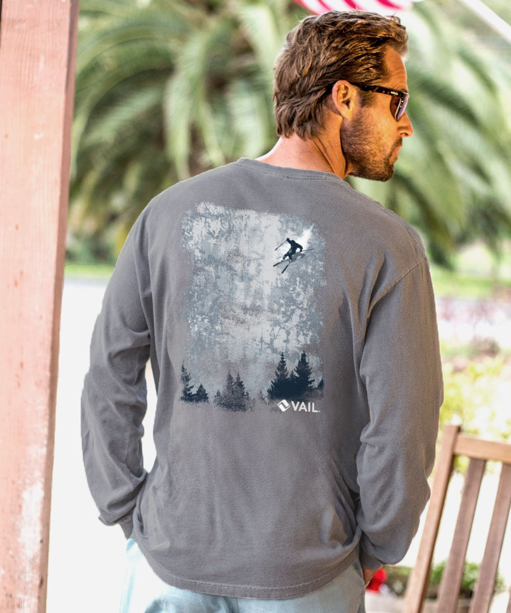 Man wearing a gray long-sleeve shirt with a graphic design on the back, standing outdoors. View 2