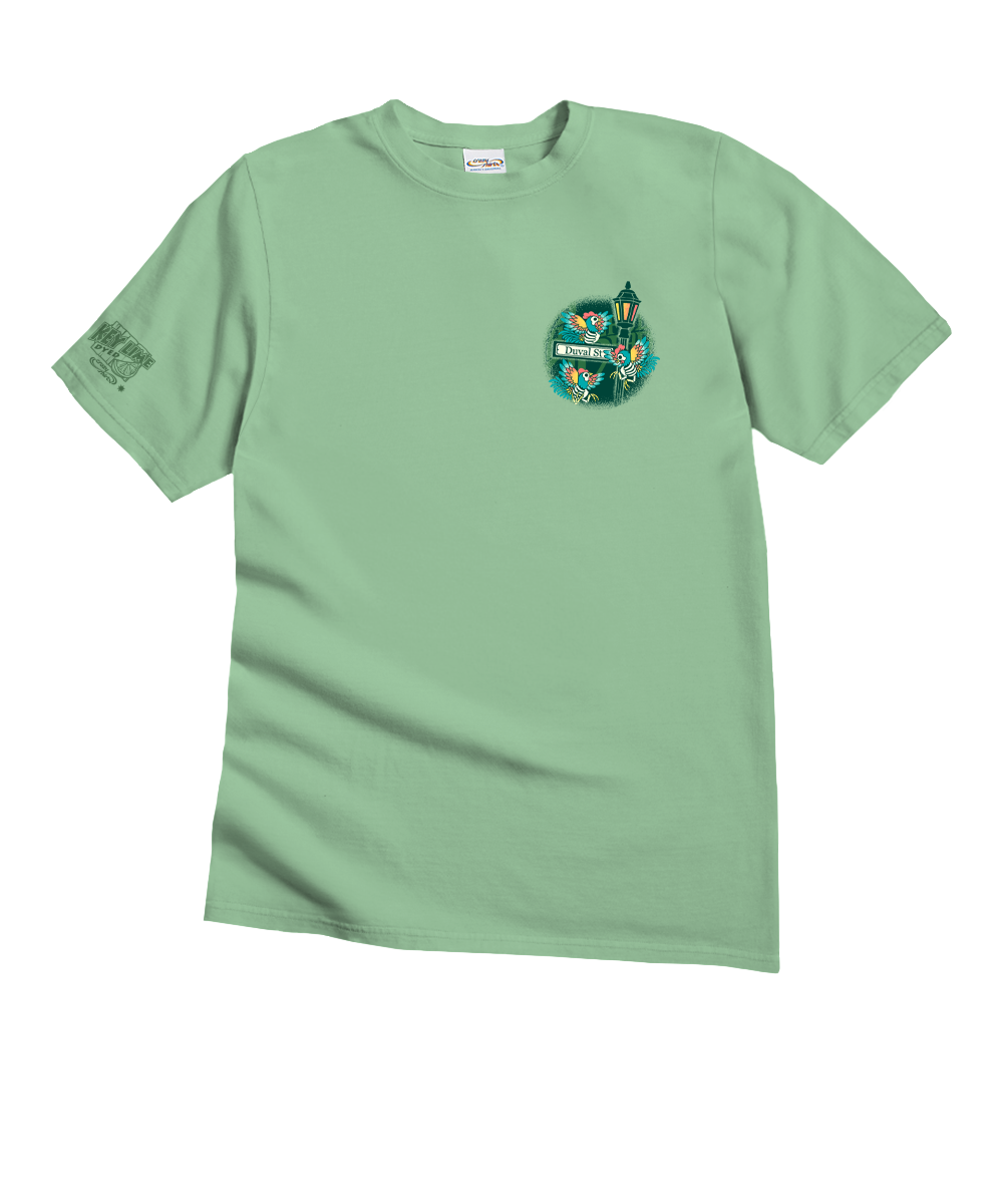 A sage green short-sleeve t-shirt with a circular graphic on the left chest featuring a green street lamp and the text 'Green Street Lamp'. The shirt is displayed flat against a solid white background. View 4