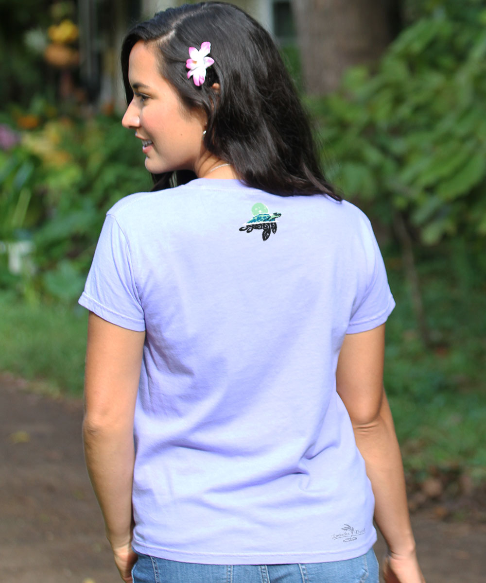 Woman wearing a light purple t-shirt with a logo on the back, standing outdoors. View 3