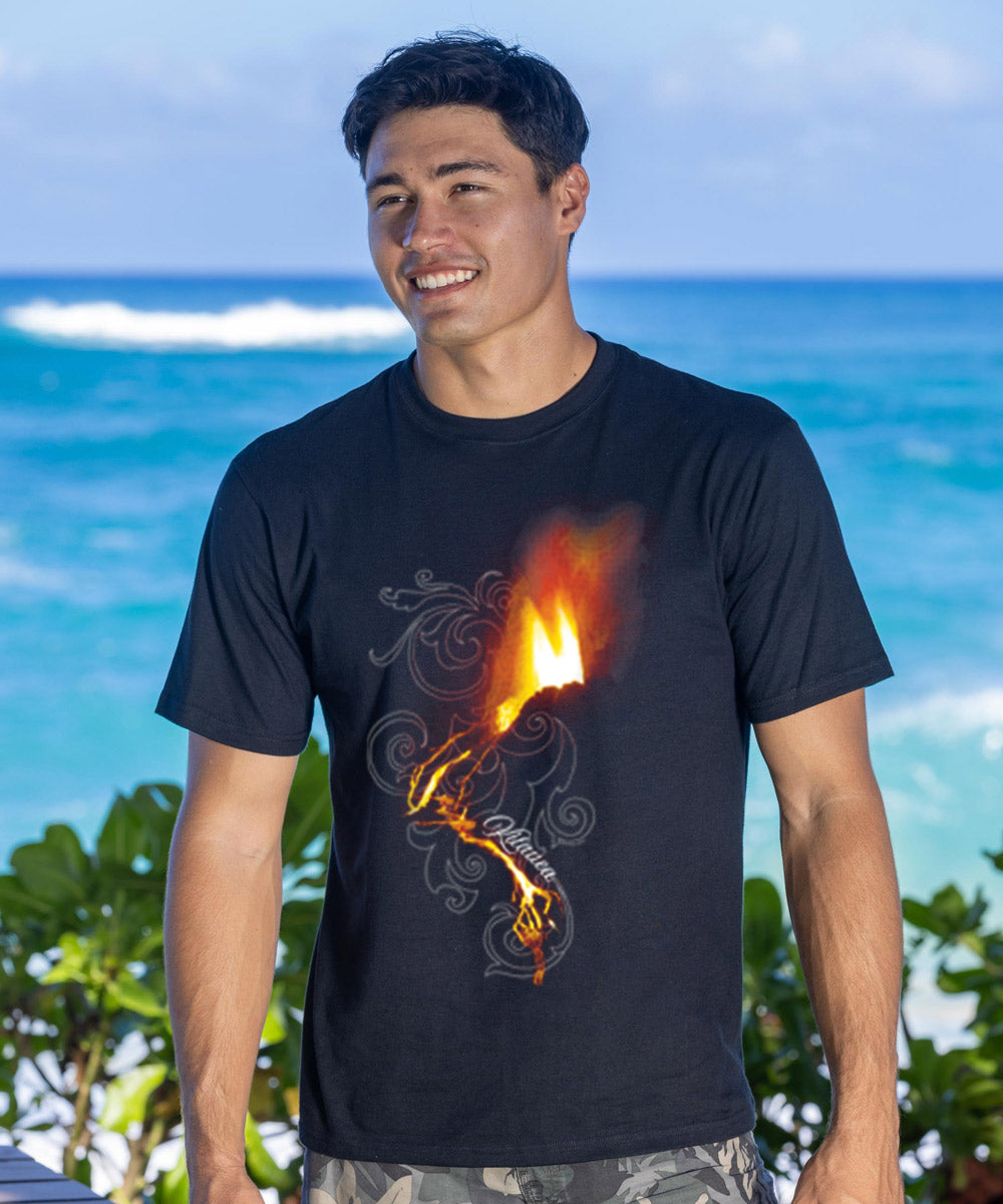 man standing on the beach wearing a black t-shirt with an erupting volcano design on it.