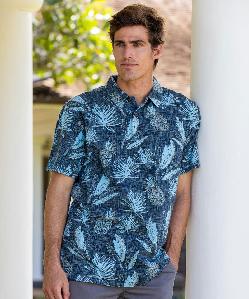 Man wearing a blue tropical shirt with leaf pattern outdoors. View 2