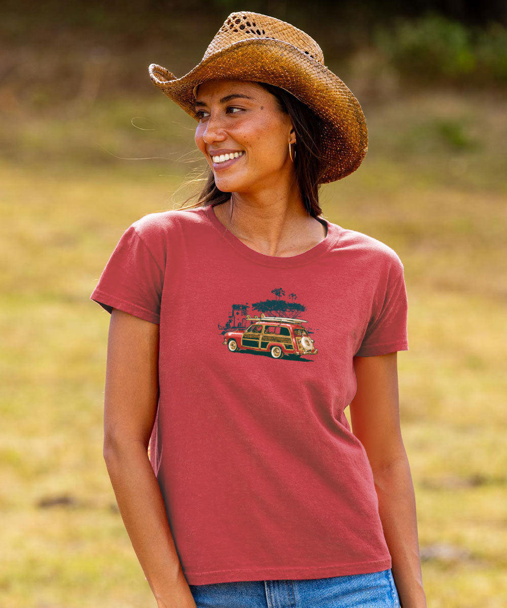 Woman wearing a red t-shirt with a graphic design, standing in a field. View 3