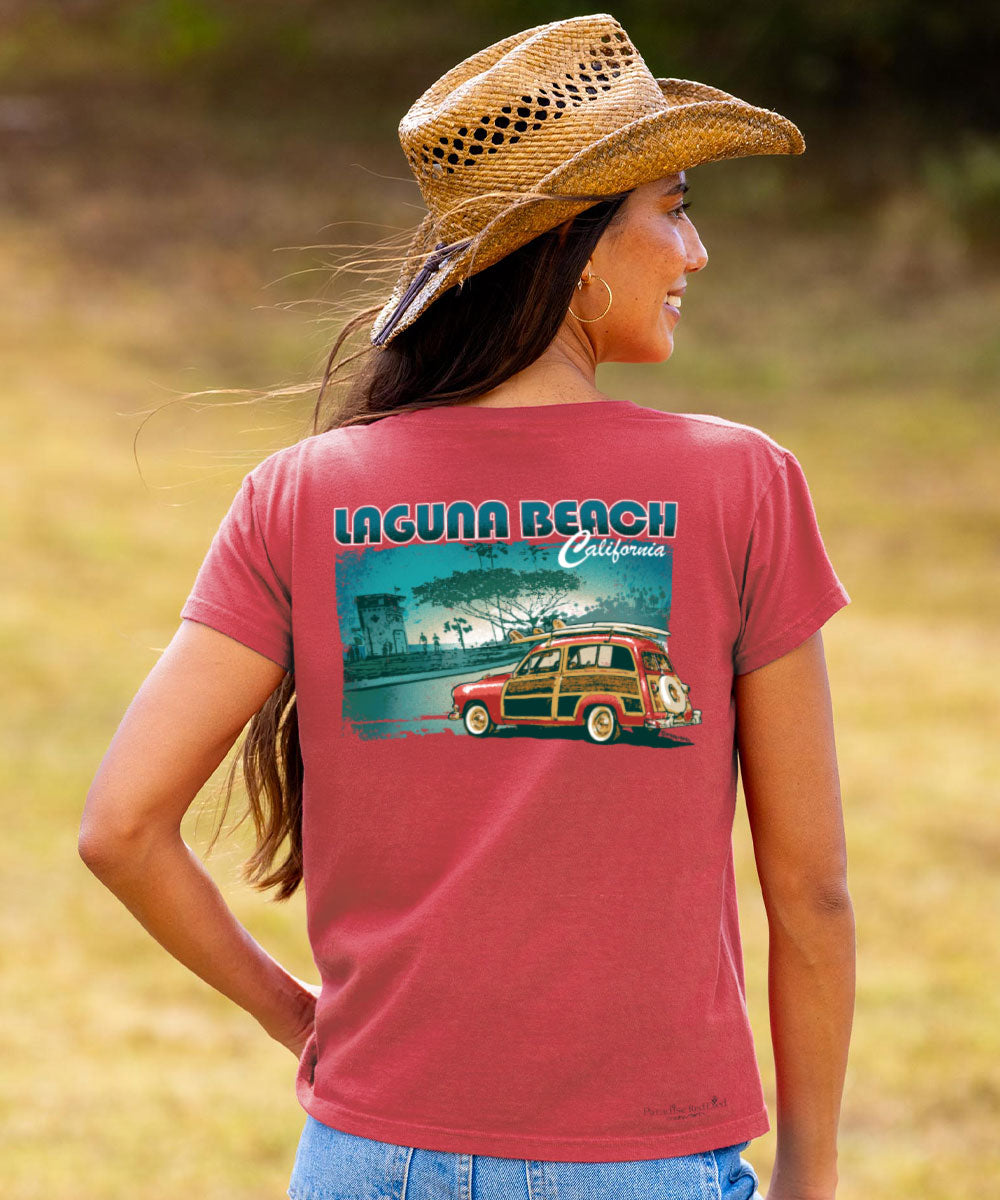 Woman wearing a red t-shirt with 'Laguna Beach California' design, standing in a field. View 2