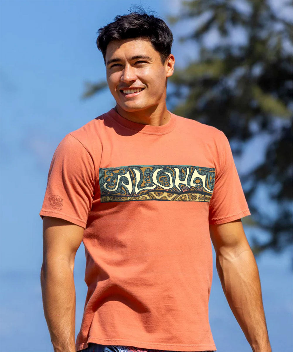 Man wearing an reddish-brown t-shirt with a 'Hawaii' logo, standing outdoors View 2