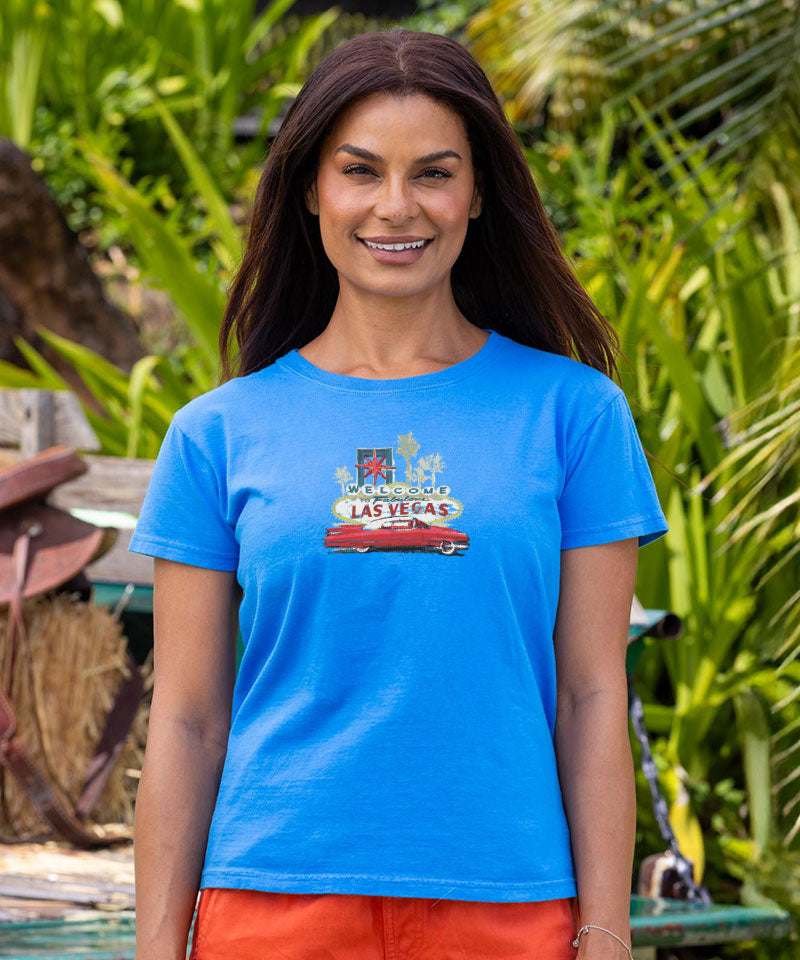 Woman wearing a blue t-shirt with a Las Vegas graphic in a tropical setting View 2