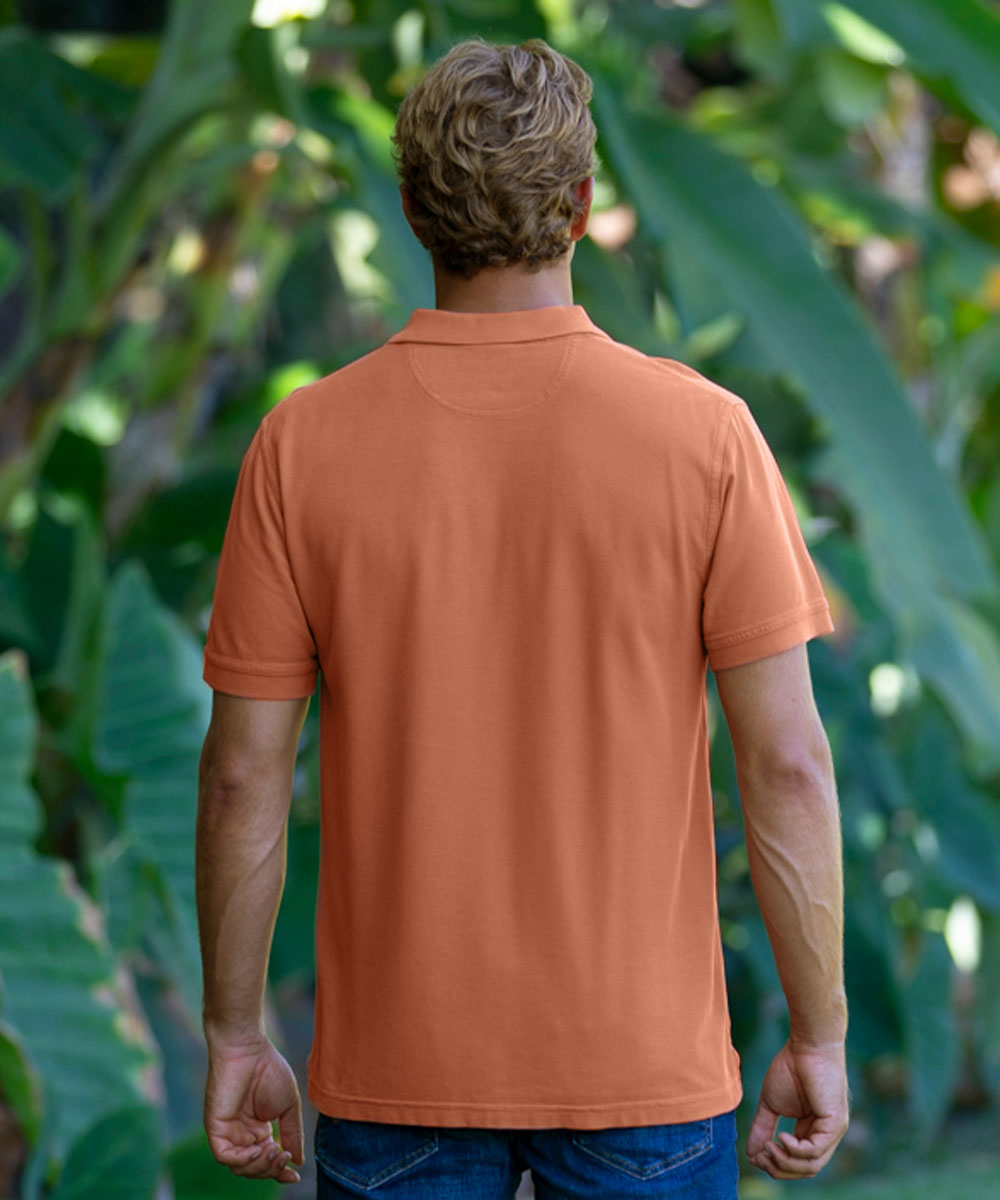 Back of man wearing a reddish-brown polo shirt with a green forest background View 3