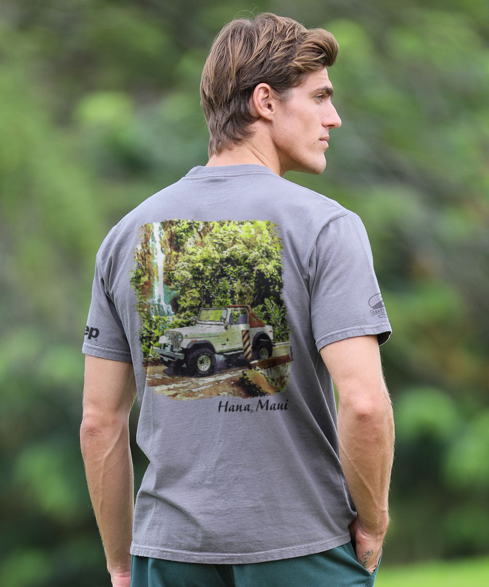 Man wearing a gray t-shirt with a Jeep graphic and text on the back, standing outdoors. View 2