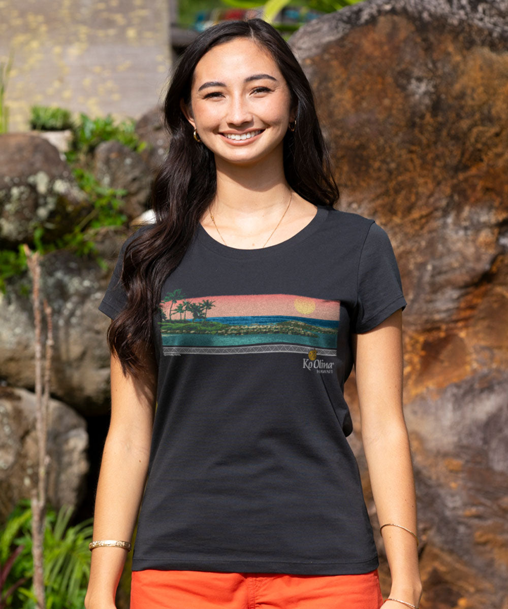 Woman wearing a black t-shirt with a scenic design, standing outdoors. View 2