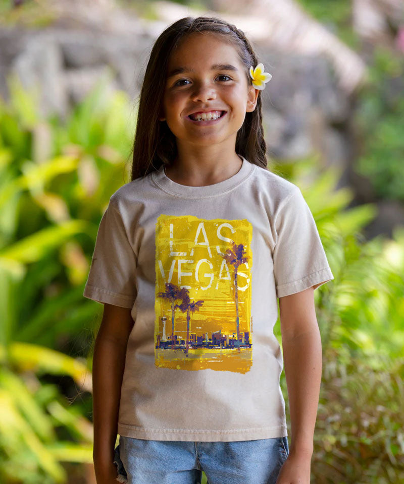 Child wearing a t-shirt with 'Las Vegas' design in a natural setting View 2