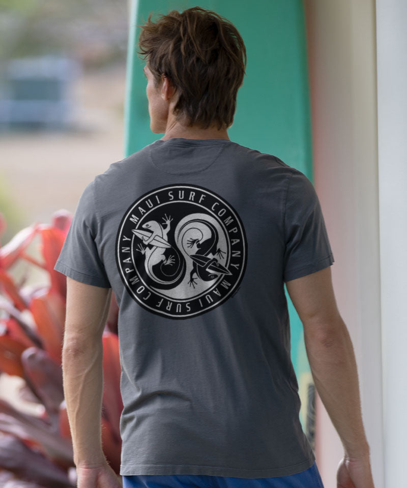 Man wearing a gray t-shirt with a logo on the back, standing outside View 2