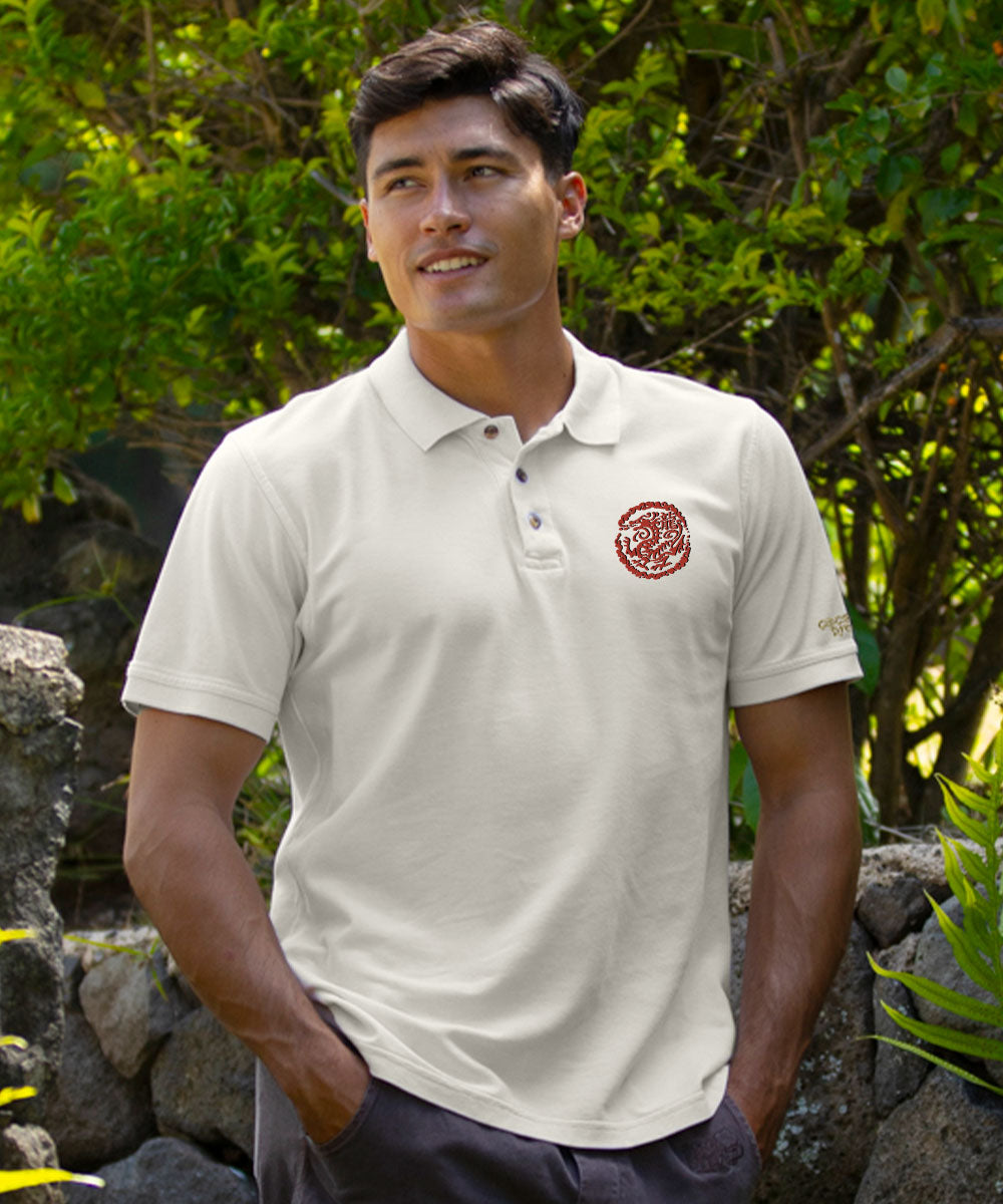Man wearing a creamy white polo shirt with a red logo outdoors View 2