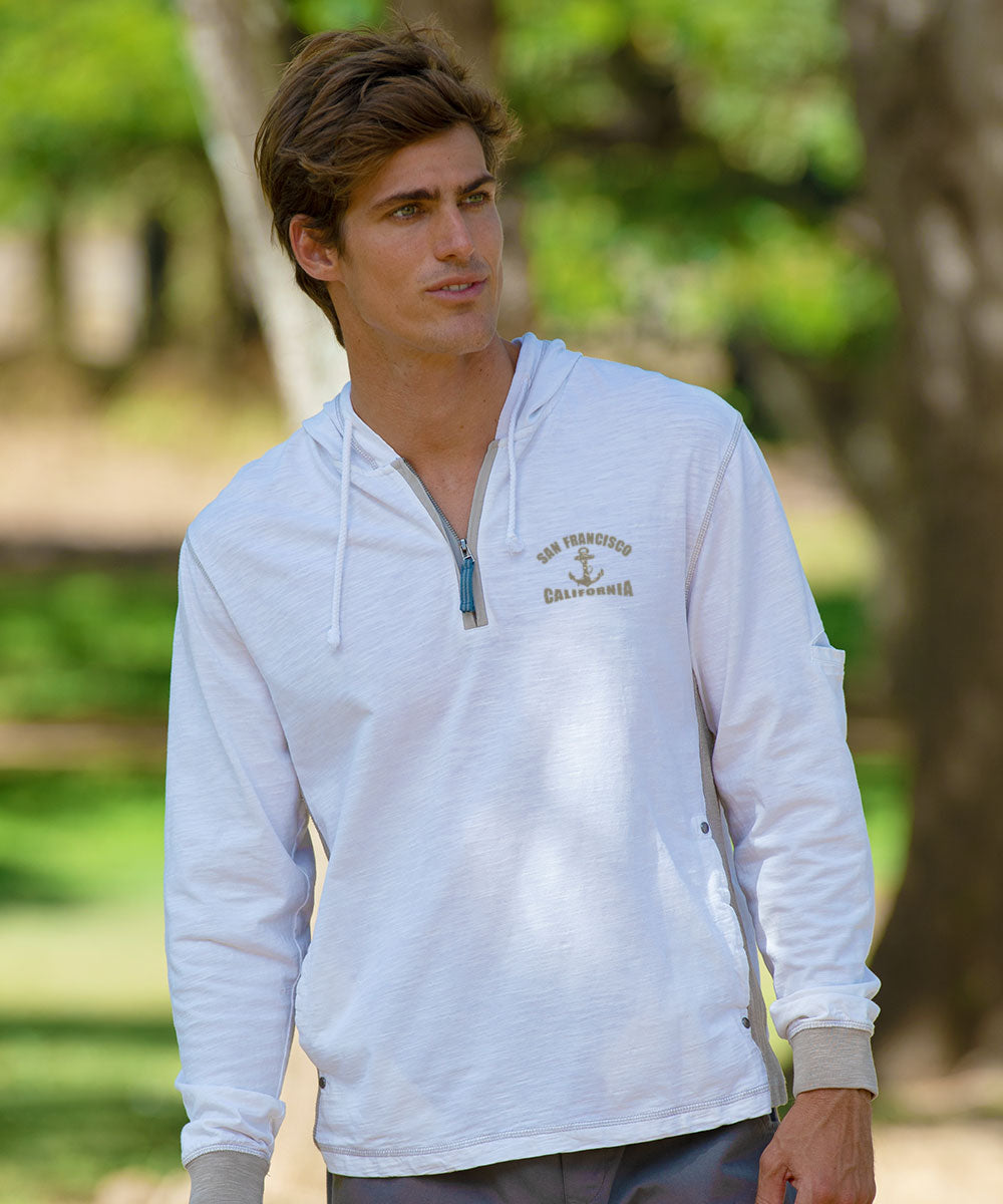 Man wearing a white jacket with a small logo standing outside View 3