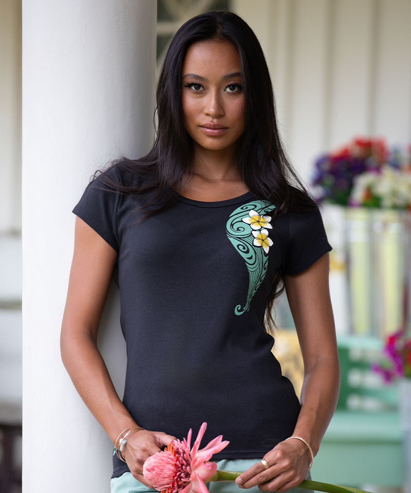 Woman wearing a black t-shirt with a floral design, holding a pink flower. View 2