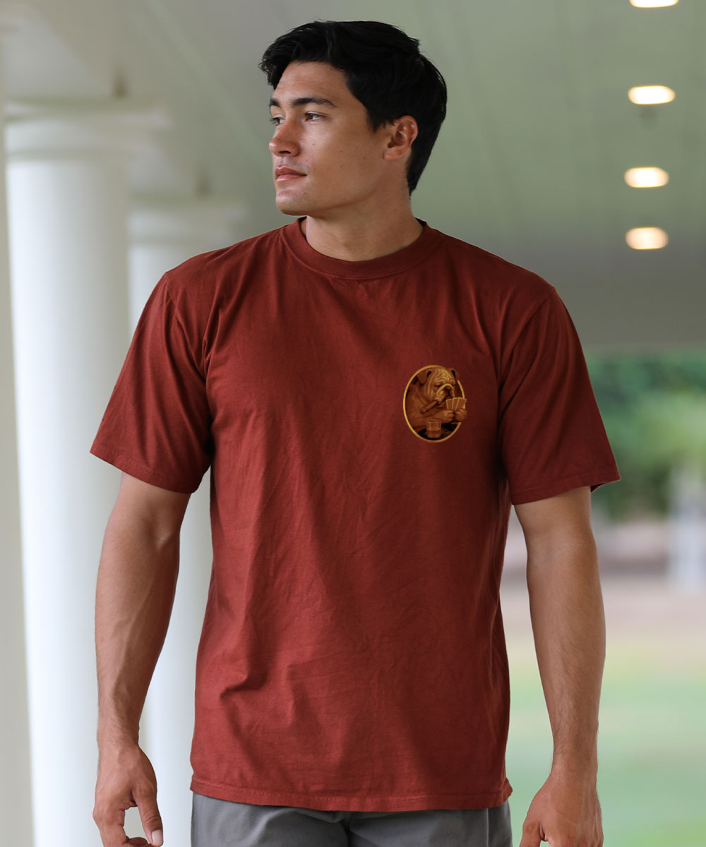 Man wearing a red t-shirt with a small logo standing on a porch View 3