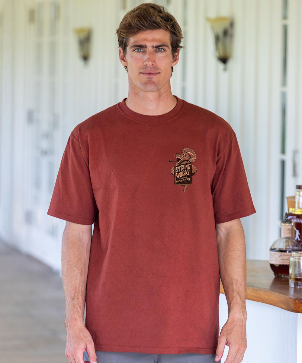 Man wearing a brown t-shirt with a logo in an indoor setting View 3
