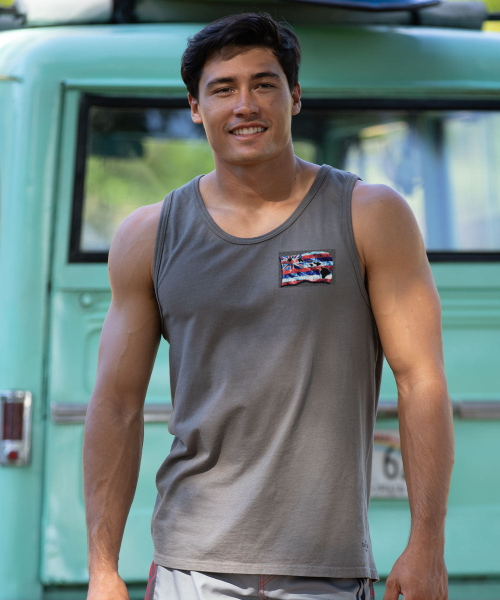 Man wearing a gray tank top with a colorful patch in front of a green vehicle. View 3