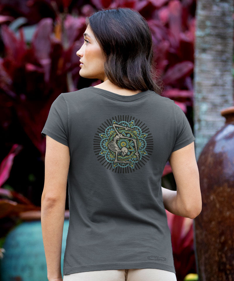 Woman wearing a gray t-shirt with a green and black design on the back, standing outdoors. View 3
