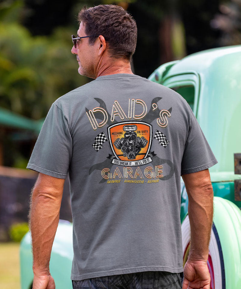 Man wearing a gray t-shirt with 'Idaids Garage' logo, standing in front of a vintage car. View 2