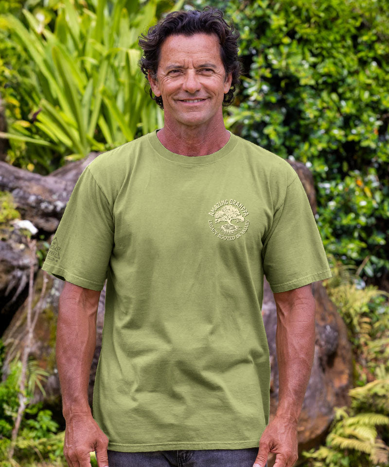 Man wearing a green t-shirt with a logo in a natural setting View 3