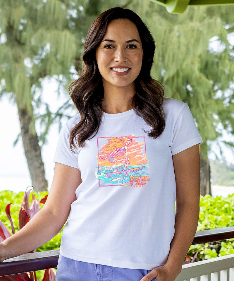 Woman wearing a white t-shirt with a colorful graphic design outdoors. View 2