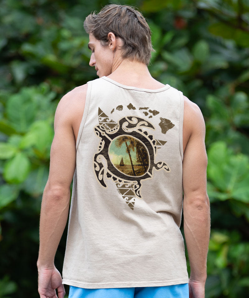 Person wearing a light brown tank top with a nature-themed design, standing in front of green foliage. View 2
