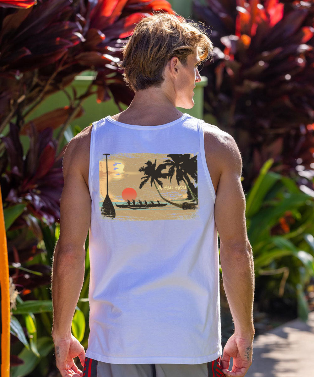 Person wearing a white tank top with a beach graphic, standing in front of tropical plants. View 2
