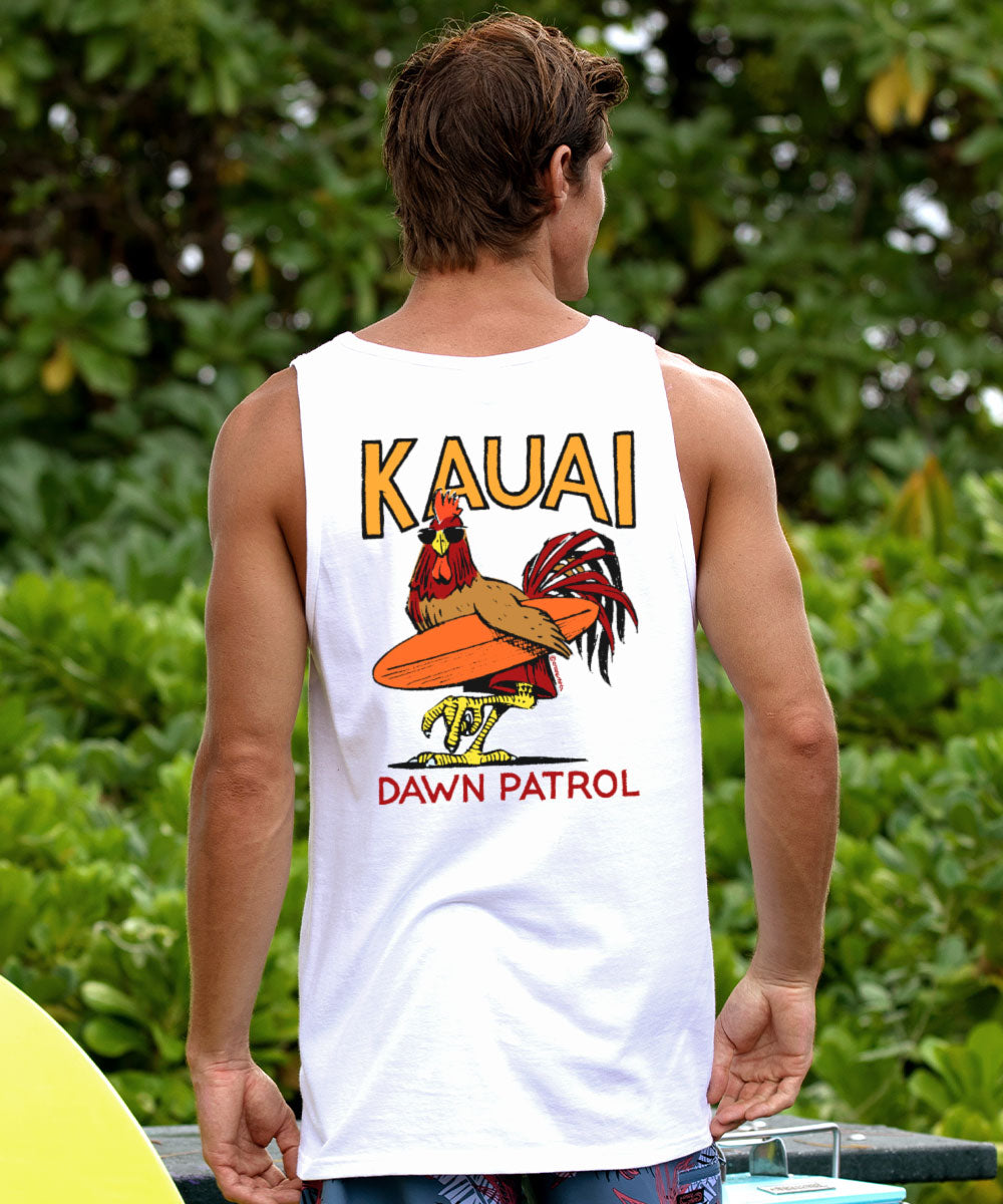 Person wearing a white tank top with 'Kauai Dawn Patrol' design outdoors. View 2