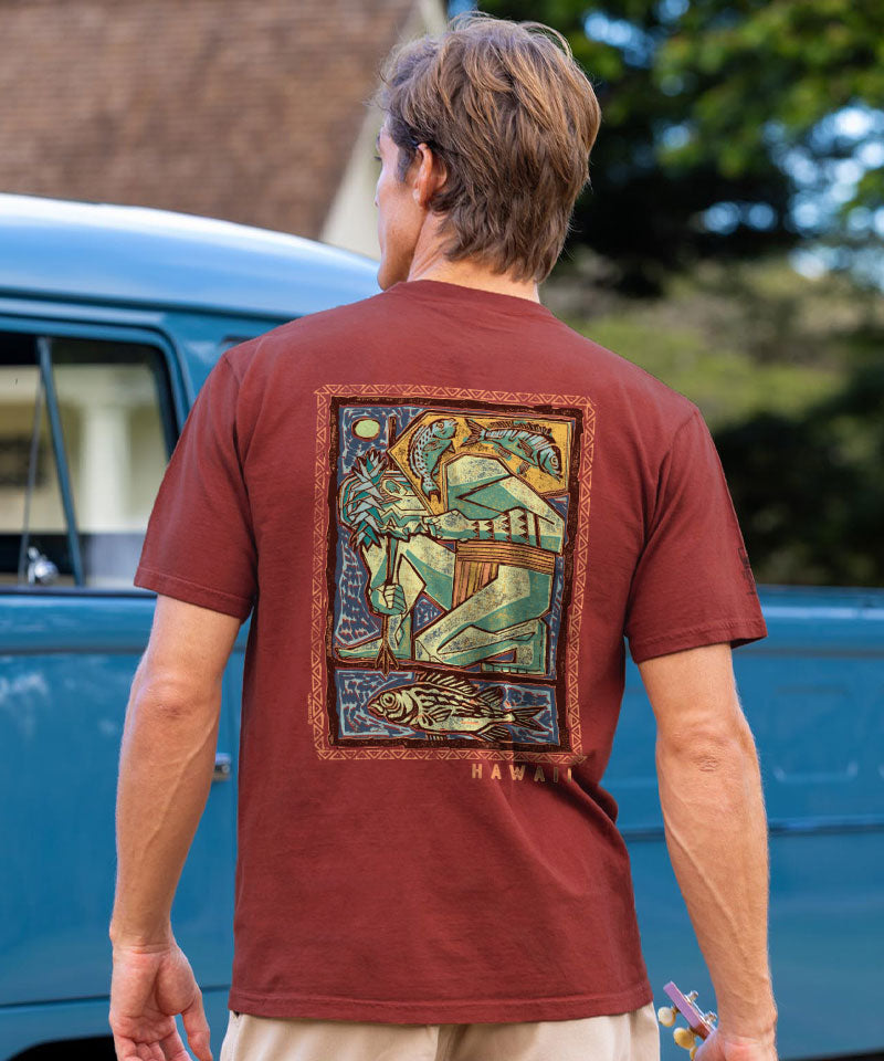 Man wearing a brown t-shirt with a colorful graphic on the back, standing in front of a blue van. View 2