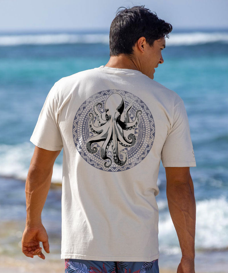 Man wearing a white t-shirt with an octopus design on the beach View 2